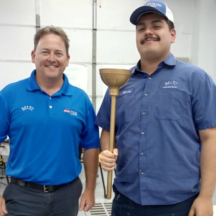 Two Beltz Home Service Company team members with a golden plunger award